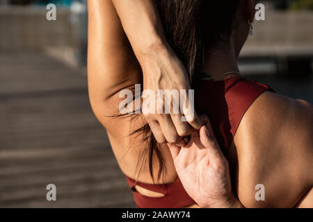 Ansicht der Rückseite des asiatischen Frau Üben Yoga, Stretching ihre Arme Stockfoto