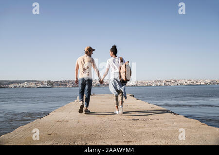 Junges Paar zu Fuß auf Pier an der Waterfront, Lissabon, Portugal Stockfoto