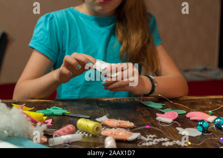 Mädchen macht Spielzeug. Mädchen werden fertig für den Urlaub. Das Mädchen ist das Nähen. Stockfoto