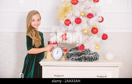 Letzte Vorbereitungen. Kind feiern Weihnachten zu Hause. Lieblings Tag des Jahres. Weihnachtsfeier. Unglaublich über Weihnachten aufgeregt. Junge Mädchen in der Nähe von Weihnachten Baum warten 24.00 Uhr. Stockfoto