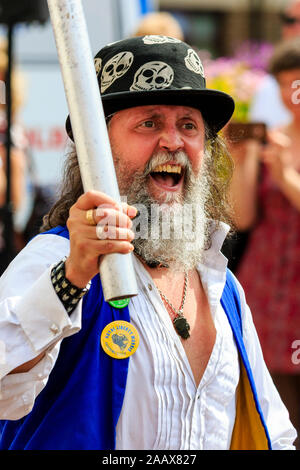 Nahaufnahme von einem jungen Mann aus der Königlichen Freiheit Morris Volkstänzer schreien und mit einem Bügeleisen bar beim Tanzen. Das Tragen eines Bowler mit Schädel auf. Stockfoto