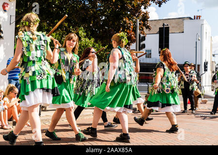 Zwei Reihen von Frauen einander gegenüber und bashing Holz- Personal zusammen. Offcumduns Morris Volkstänzer tanzen in street Faversham Hop Festival Stockfoto