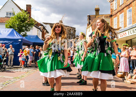 Zwei junge Frauen tanzen in Richtung Betrachter und Holding Holz- Mitarbeiter. Offcumduns Morris Volkstänzer tanzen in der Straße an der Faversham Hop Festival Stockfoto