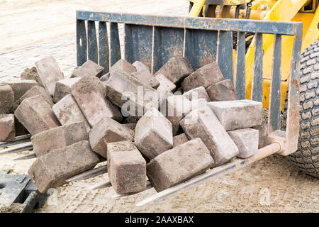 Haufen Backsteine auf Sieb Schaufel von kleinen Bagger Stockfoto