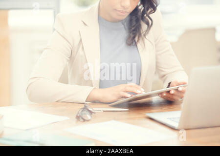 In der Nähe der Jugendlichen mixed-race Geschäftsfrau mit digitalen Tablet am Arbeitsplatz, im Raum kopieren Stockfoto