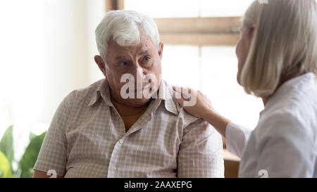 Ältere Menschen hören auf unterstützende Rede von angenehmen Arzt umgekippt. Stockfoto