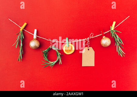 Weihnachten handgefertigte Girlande aus 2020 Holz- Ziffern und Tannenbaum, Zweige und andere Weihnachtsdekorationen auf rotem Hintergrund. Stockfoto