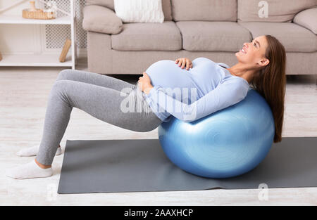 Schwangere Mädchen arbeiten mit Fitness Ball zu Hause Stockfoto