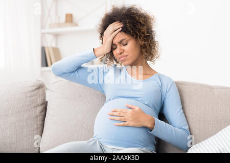 Schwangere afro Mädchen leiden unter Kopfschmerzen zu Hause Stockfoto