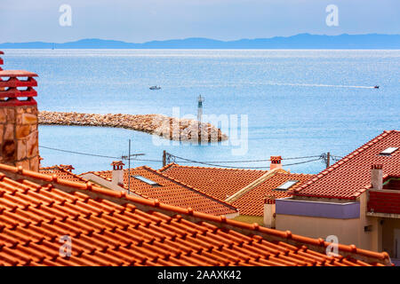 Nikiti, Sithonia, Chalkidiki, Griechenland Halbinsel Panorama mit roten Dächern Häuser, blaue Meer und die Pier Stockfoto