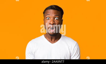Überrascht Afro Mann mit Kamera im Studio, Panorama stehend Stockfoto