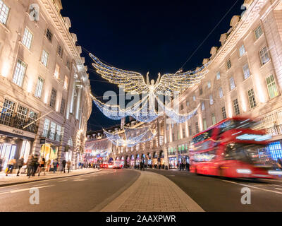 Engelsdekorationen beleuchtet und ein roter Doppeldeckerbus in Bewegung auf Regents Street in London in Weihnachtsferien, England Stockfoto