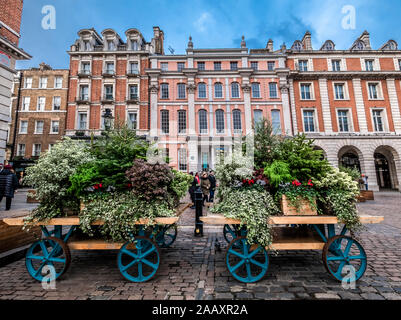 London, England, Großbritannien - 15 November, 2019: Vintage Pferdekutsche mit frischen Blumen in der Altstadt von Covent Garden in Weihnachten hol eingerichtet Stockfoto