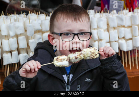 Glasgow, UK. 24. November 2019, im Rahmen der festlichen Glasgow's feiern, der jährliche Weihnachtsmarkt offiziell eröffnet in der Stadt George Square mit einem Jahrmarkt, Geschenkeladen und Chalets verkauf einer Auswahl an internationalen Speisen. George Square ist traditionell das Zentrum der Feierlichkeiten der Stadt und alle Ecken sind für Tausende von Touristen, die die Stadt und die Märkte besuchen wird vorbereitet. Bild von ROBBIE WHELAN, im Alter von 7 von Glasgow genießen Sie amerikanische gerösteten Marshmallows. Credit: Findlay/Alamy leben Nachrichten Stockfoto