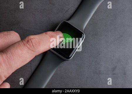 Man Berühren der WLAN-Zeichen auf dem Bildschirm von smart Watch Stockfoto