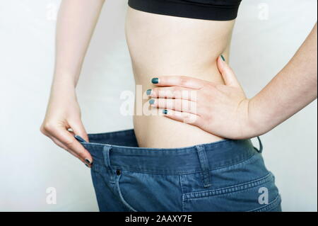 Frau zeigen, wie viel Gewicht Sie verlor. Gesunde Lebensführung Konzept Stockfoto