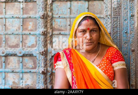 Porträt einer indischen Frau in bunte traditionelle Kleidung gegen eine alte Tür Stockfoto