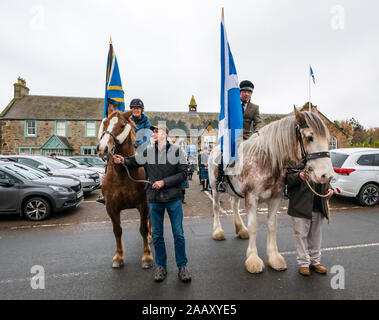 Athelstaneford, East Lothian, Schottland, Großbritannien. 24. November 2019. Saltire Festival: Der erste Tag des jährlichen Festival zu markieren St Andrew's Day statt, der Geburtsort des Scottish National Flagge, wo die saltire am Himmel erschien als ein gutes Omen, wenn die Pikten und Schotten besiegten die Sachsen unter der Führung von athelstan. Catherine Campbell auf Chestnut irischen Entwurf/Welsh Cob Stute mit Bräutigam Robert Campbell & Craig Donnelly zu Strawberry Roan Clydesdale Stute mit Bräutigam/Inhaber Arthur Greenan Stockfoto