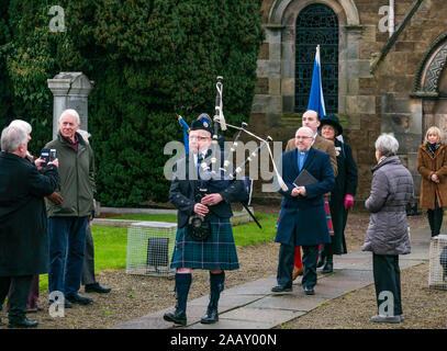 Athelstaneford, East Lothian, Schottland, Großbritannien. 24. November 2019. Saltire Festival: Der erste Tag des jährlichen Festival zu markieren St Andrew's Day statt, der Geburtsort des Scottish National Flagge, wo die saltire am Himmel erschien als ein gutes Omen, wenn die Pikten und Schotten besiegten die Sachsen unter der Führung von athelstan. Nach einem Gottesdienst, Haddington Pipe Band Piper der Minister & Fraser Thompson der schottische Flagge Vertrauen in die Gedenkstätte führt eine neue Saltire zu segnen. Stockfoto