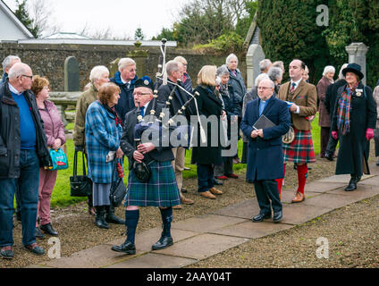 Athelstaneford, East Lothian, Schottland, Großbritannien. 24. November 2019. Saltire Festival: Der erste Tag des jährlichen Festival zu markieren St Andrew's Day statt, der Geburtsort des Scottish National Flagge, wo die saltire am Himmel erschien als ein gutes Omen, wenn die Pikten und Schotten besiegten die Sachsen unter der Führung von athelstan. Nach einem Gottesdienst, Haddington Pipe Band Piper der Minister & Fraser Thompson der schottische Flagge Vertrauen in die Gedenkstätte führt eine neue Saltire zu segnen. Stockfoto