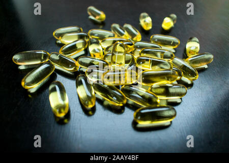 Omega-3 Lebertran in gel Kapseln auf schwarzem Hintergrund. Stockfoto