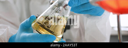 Männliche Chemiker Blick an Mikroskop halten Reagenzglas Stockfoto