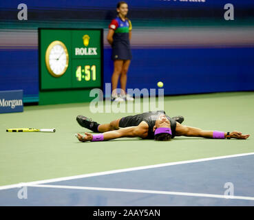 Spanischer Tennisspieler Rafael Nadal feiert am gleichen Punkt und lässt sich auf den Boden während 2019 US Open Tennis Turnier fallen, New York C Stockfoto