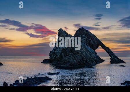 Bogen GEIGE ROCK PORTKNOCKIE Moray in Schottland ROT UND GOLD SOMMER SONNENAUFGANG MIT EINEM RUHIGEN MEER Stockfoto