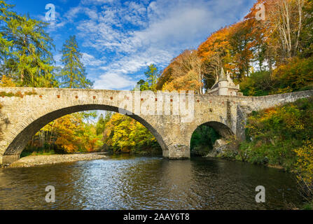 Alte Brücke von AVON BALLINDALLOCH CASTLE SPEYSIDE SCHOTTLAND DIE BRÜCKE ÜBER DEN FLUSS mit Bäumen und Blätter in Herbstfarben Stockfoto