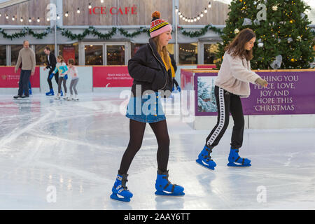 Schlittschuhläufer Spaß auf der Eislaufbahn auf Winchester Cathedral Eisbahn an der Winchester, Hampshire, UK im Dezember Stockfoto