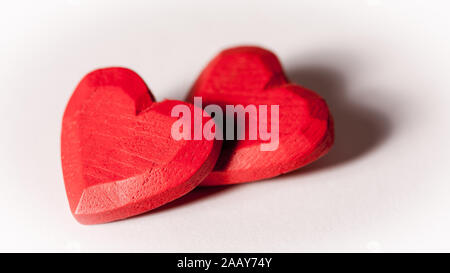 Liebe und Valentinstag: die Liebe die Herzen. Ein Paar rote aus Holz geschnitzte Herz isoliert auf Weiss. Stockfoto