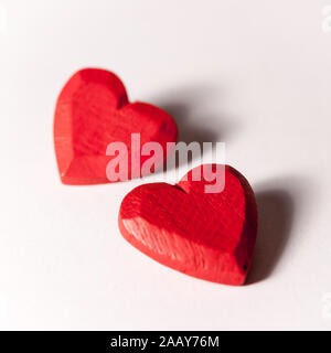 Liebe und Valentinstag: die Liebe die Herzen. Ein Paar rote aus Holz geschnitzte Herz isoliert auf Weiss. Stockfoto