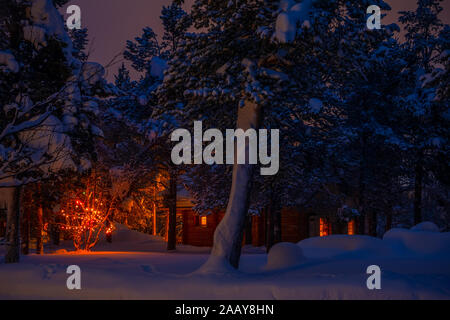 Holz- Haus in der Nacht Winter Forest und Weihnachten Girlande. Viel Schnee Stockfoto