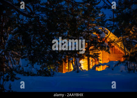 Holz- Haus in der Nacht Winter Forest. Viel Schnee Stockfoto