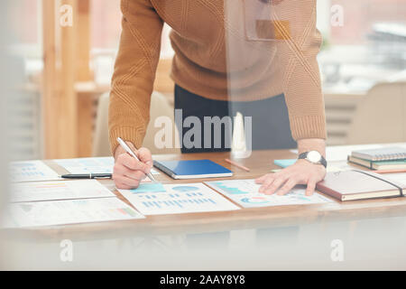 7/8-portrait der junge Unternehmer Analyse Statistik Diagramme und Diagramme während der Planung Projekt hinter Glas Wand im Büro, kopieren Raum Stockfoto