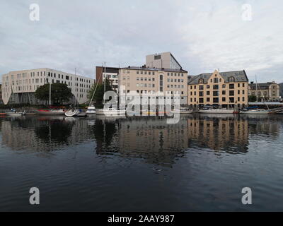 Yachten und Boote vor der abtrünnigen Zentrum der europäischen Stadt Alesund in Wasser bei Romsdal Region in Norwegen wider, bewölkter Himmel 2019 warme s Stockfoto