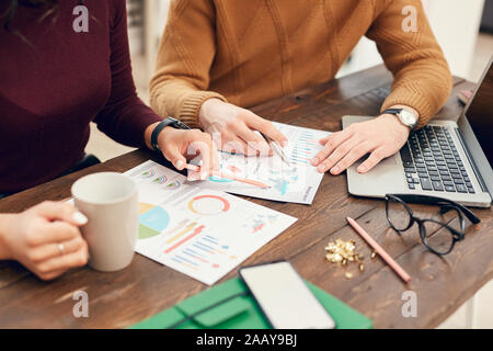 Hintergrund Der junge Geschäftsleute oder Studenten Daten analysieren Charts an der hölzernen Schreibtisch sitzen beim arbeiten oder studieren, kopieren Raum Stockfoto