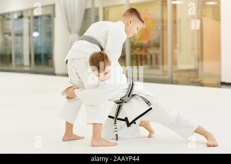 Zwei Männer in weißen Kimono kämpfen miteinander während der Ausbildung in Karate in der Turnhalle Stockfoto