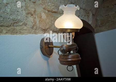 Stilvolle Lampe auf der Tapete. Wandleuchte aus vergoldetem Metall mit zwei elektrischen Kerzen. vintage Wandleuchte in Weiß mit Freistellungspfad isoliert. Warm Stockfoto