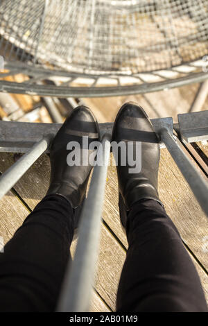 Blick vom Turm nach unten auf der Treppe und Beine von oben Stockfoto