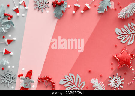 Weihnachten flach mit Rahmen von Dekorationen - Winter verlässt, Puppen, Girlanden und Schneeflocken. Blick von oben auf die bunten geometrischen layered Papier backgr Stockfoto