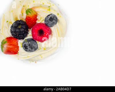 Baiser Pavlova mit Sahne und frischen Beeren, Erdbeeren, Himbeeren, Heidelbeeren isoliert auf weißem Stockfoto