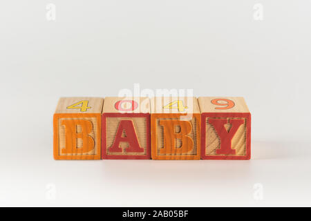 Ein Kind im Alphabet Spielzeug Rechtschreibung Wort Block gesetzt, in denen das Wort Baby über dem Rahmen Stockfoto