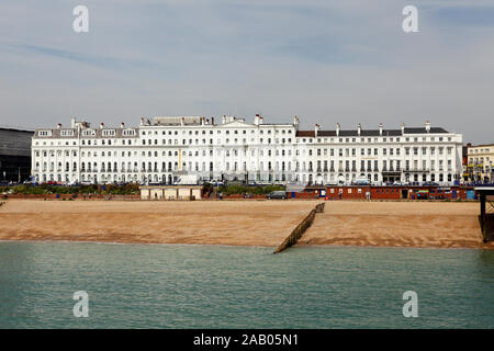 Hotels am Meer und die Pier mit mehreren Leistengegend auf Eastbourne Strand, hier an einem bewölkten Tag gesehen im Mai 2019. Stockfoto