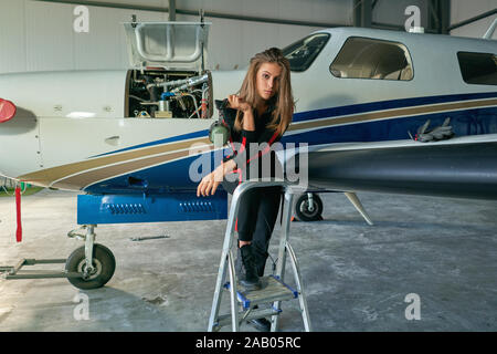 Mädchen Techniker in den Hangar mit dem Flugzeug Stockfoto