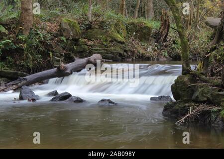 Ein kleiner Wasserfall entfernt in einem Park versteckt. Stockfoto