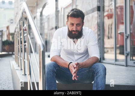 Eine schöne bärtige Mann in der alltäglichen Kleidung sieht in die Kamera. Stockfoto