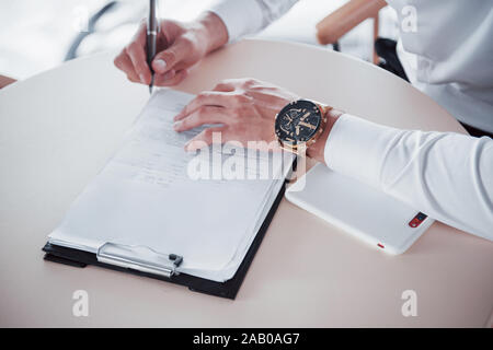 Junger Mann zeichen Dokumente im Büro, erfolgreiche Vertriebs Stockfoto