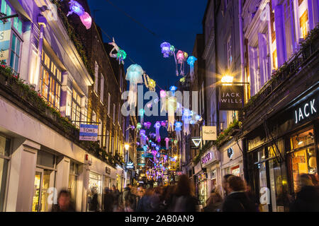LONDON, Großbritannien - 24. Nov. 2019: Dekorationen entlang Fouberts place als Teil der Carnaby Street Weihnachten leuchten. Menschen gesehen werden kann. Stockfoto