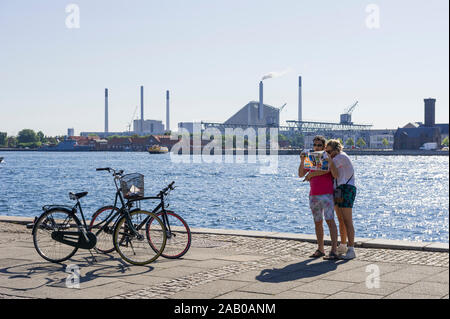 Ein Paar auf der Suche nach einem Papier von der Hafenseite, Kopenhagen, Dänemark Stockfoto